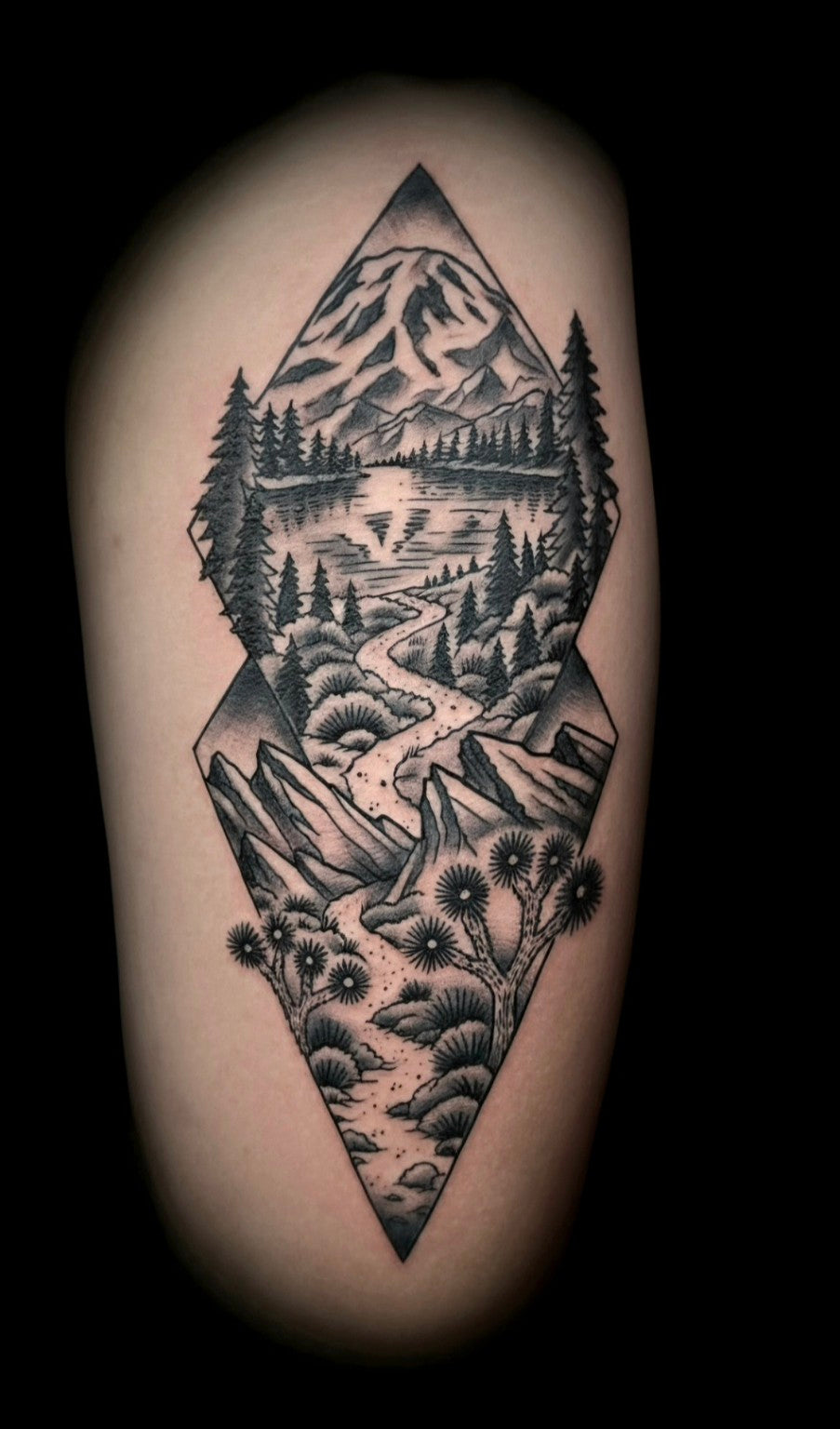 Black-and-gray geometric mountain landscape tattoo by Thomas Ingram